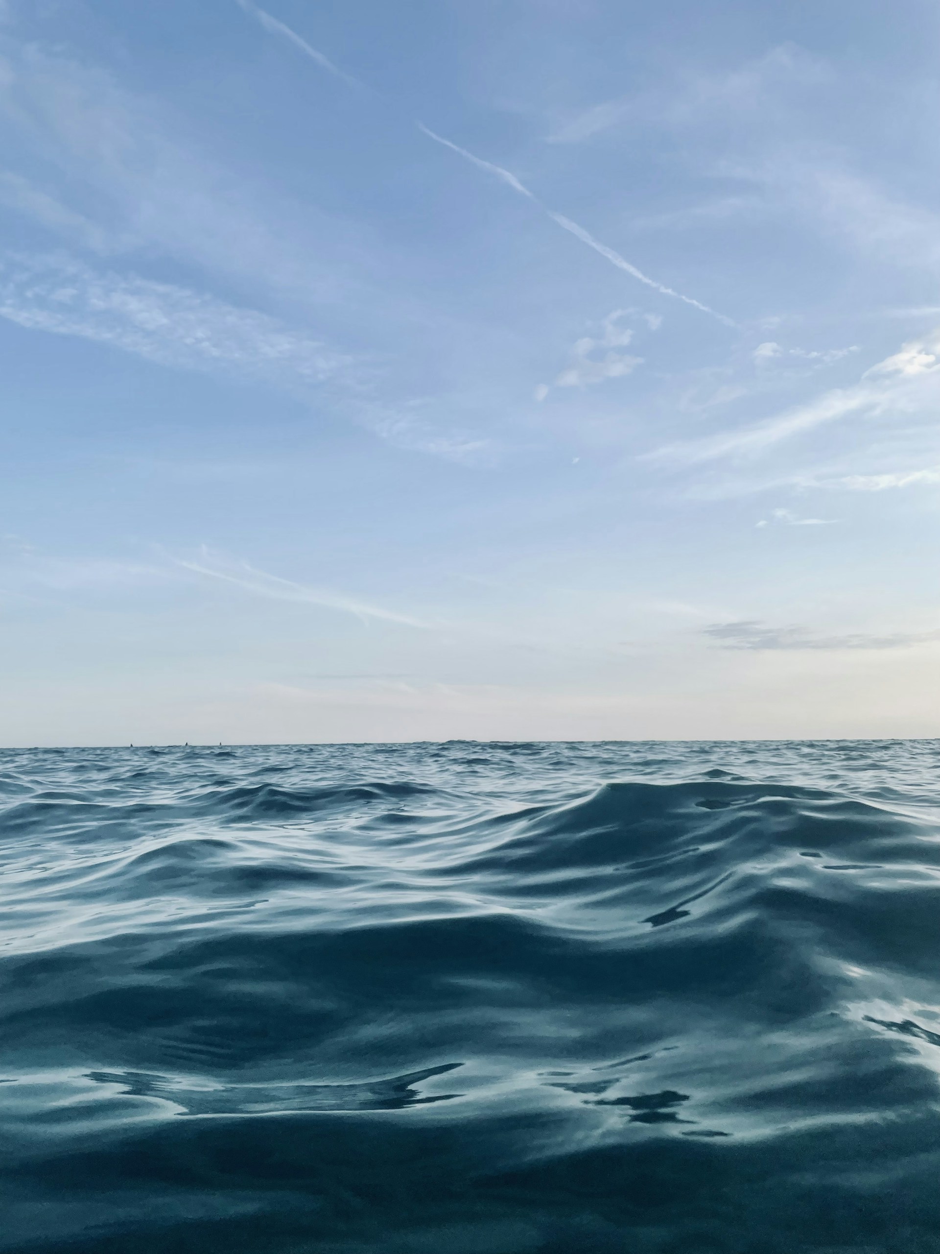 a large body of water with a sky in the background