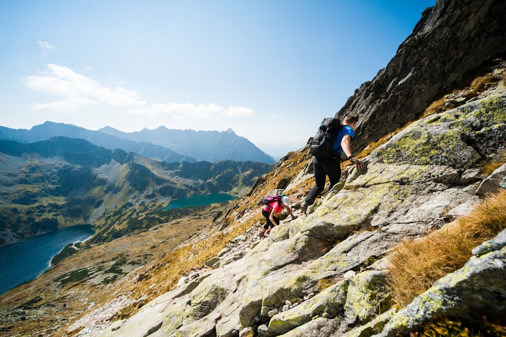 a man climbing up a mountain with a backpack