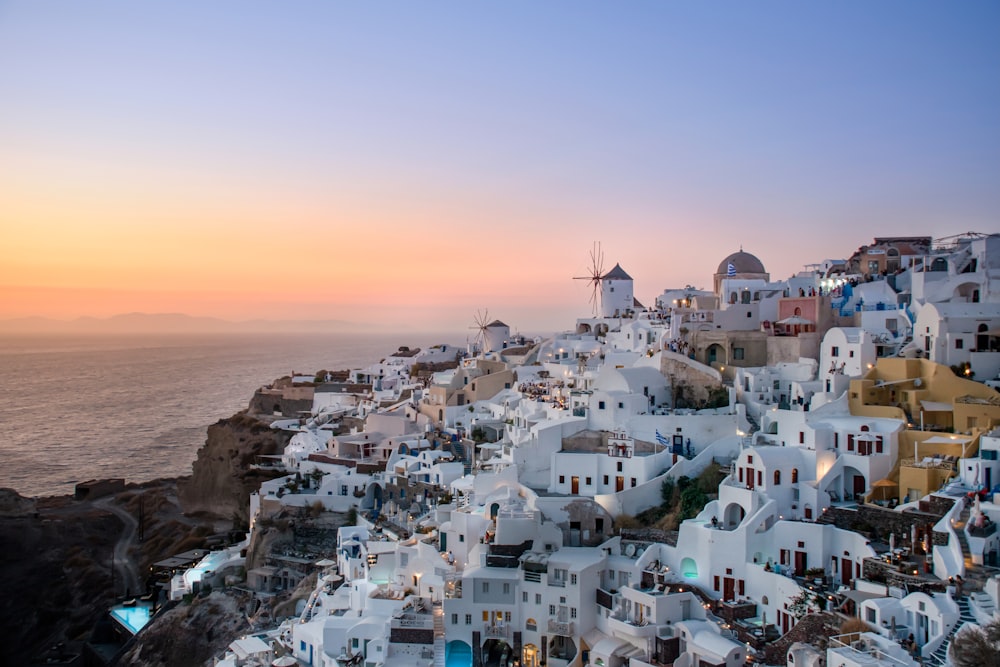 a sunset view of a village on a cliff