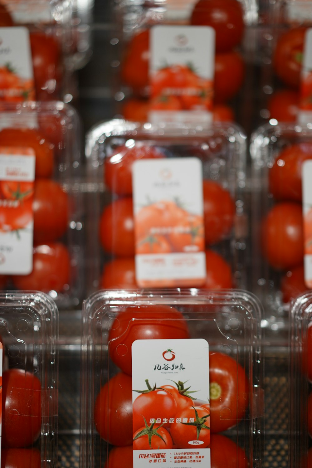 a display case filled with lots of red tomatoes