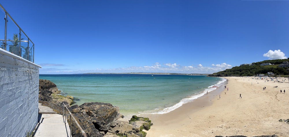 a sandy beach with people walking on it