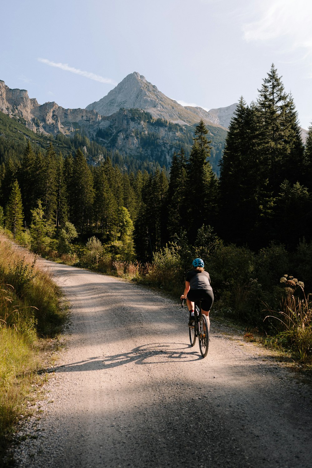 a man riding a bike down a dirt road