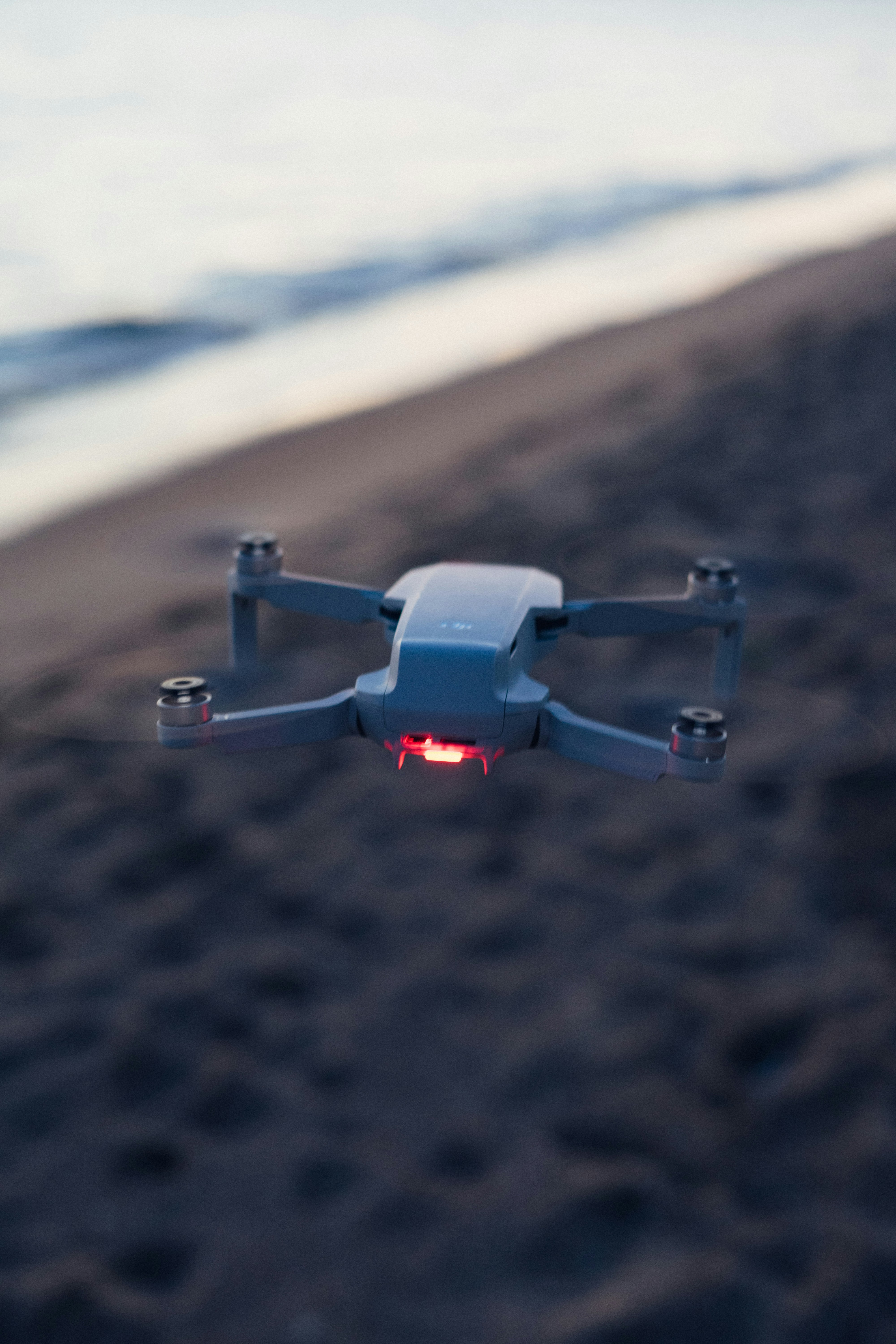 un piccolo oggetto blu e bianco che vola sopra una spiaggia
