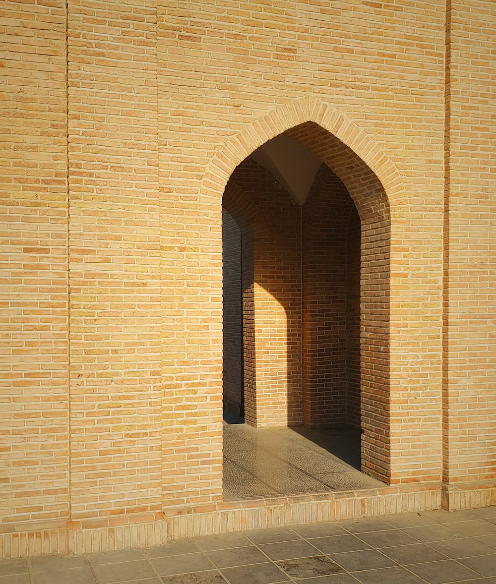 a brick wall with an arched doorway in the middle