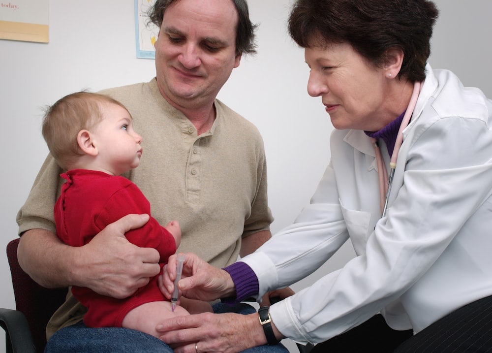 a doctor examines a baby's chest with a stethoscope