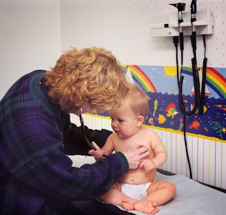 a woman with a stethoscope examines a baby's chest