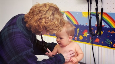 a woman with a stethoscope examines a baby's chest