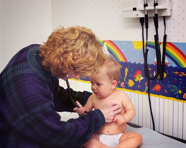 a woman with a stethoscope examines a baby's chest