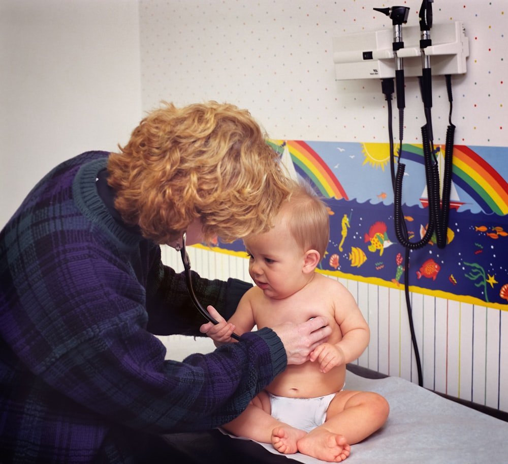 Una donna con uno stetoscopio esamina il petto di un bambino