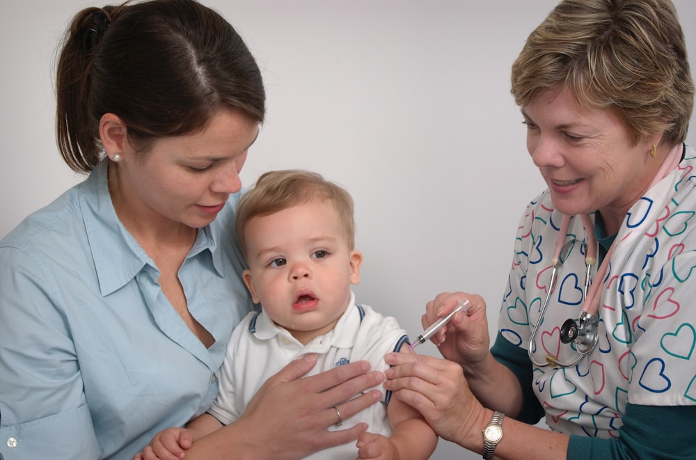 Ein Baby wird von einem Arzt und einer Krankenschwester untersucht