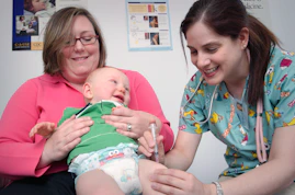 a woman holding a baby in a hospital room