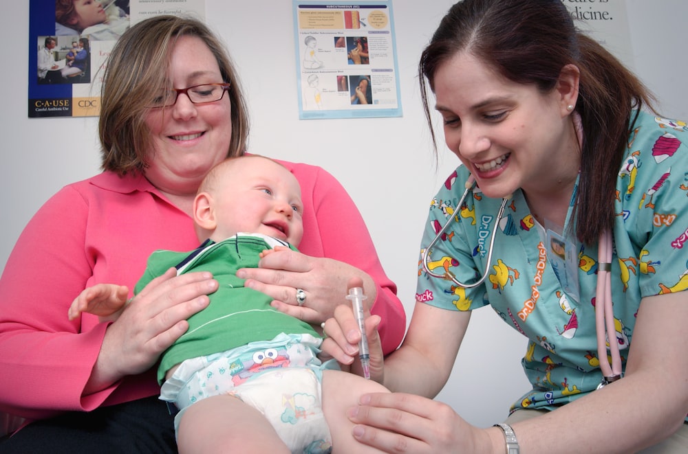 a woman holding a baby in a hospital room