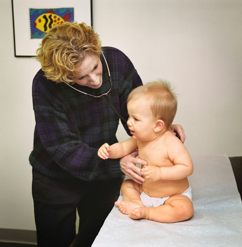 a woman holding a baby on top of a table