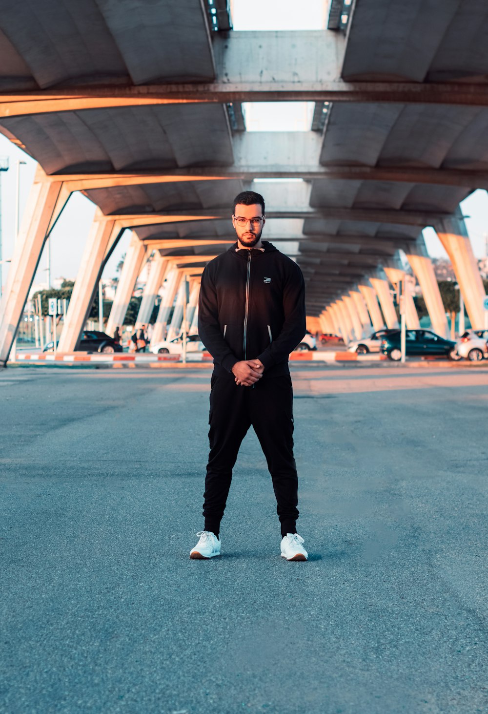 a man is standing in the middle of an empty parking lot