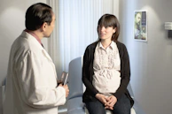 a doctor talking to a pregnant woman in a waiting room