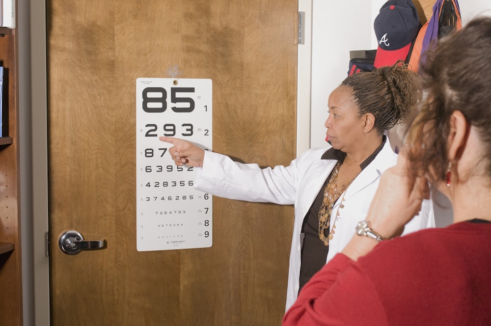 a woman pointing at a sign on a door