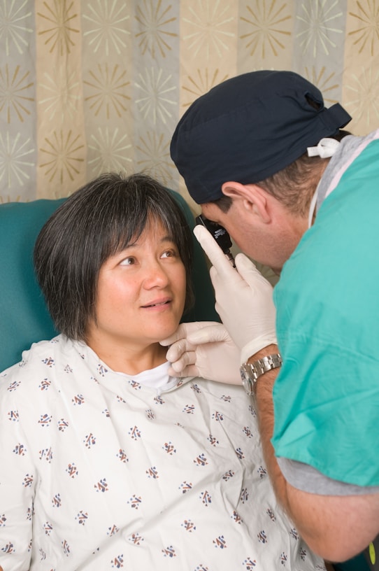 a woman in a hospital gown getting her teeth checked