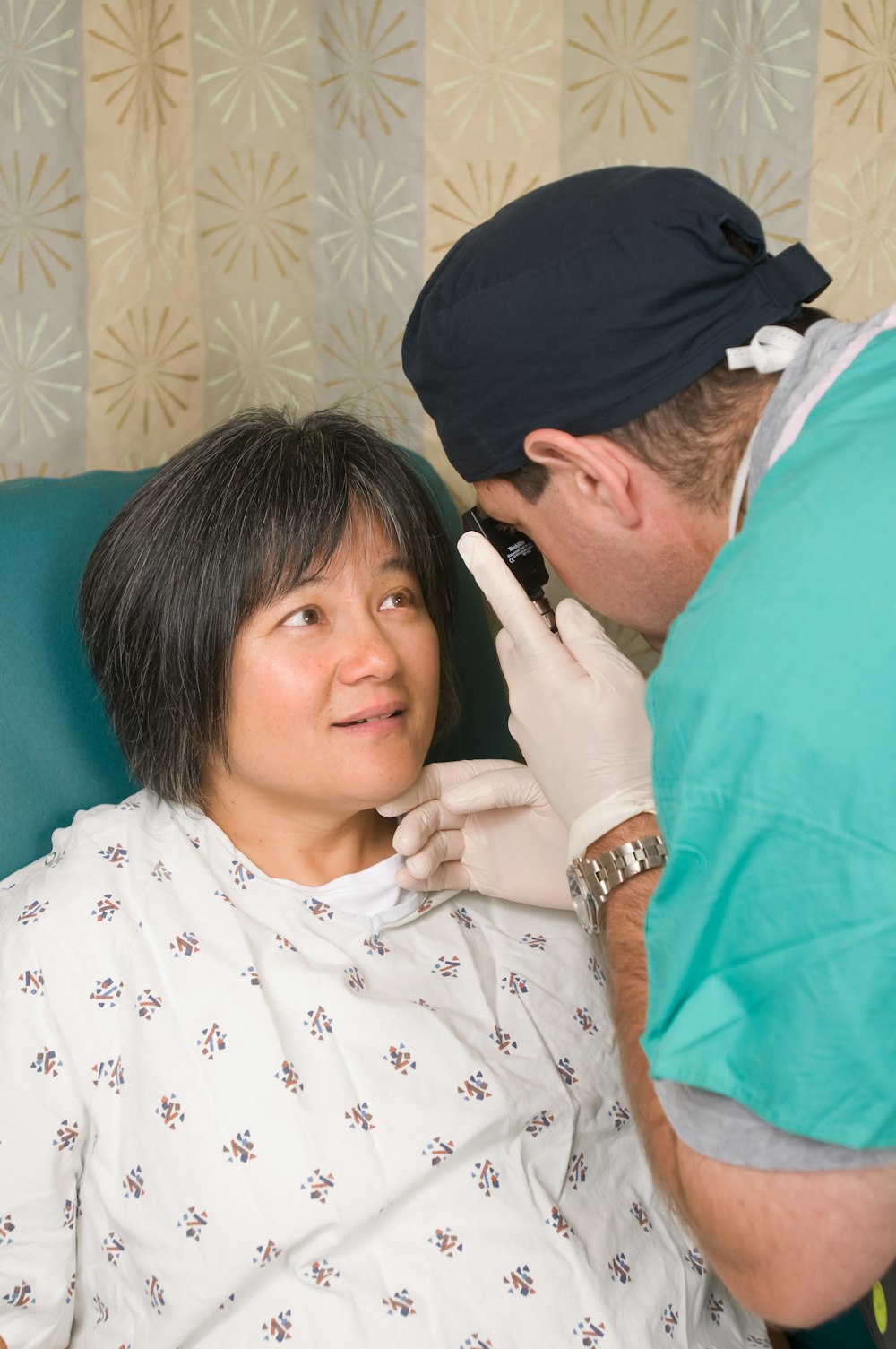 Une femme en blouse d’hôpital se fait faire vérifier les dents