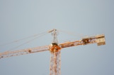 a yellow crane is against a blue sky