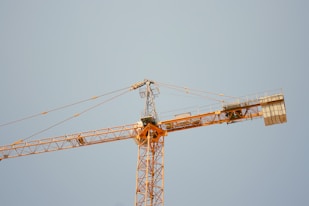 a yellow crane is against a blue sky