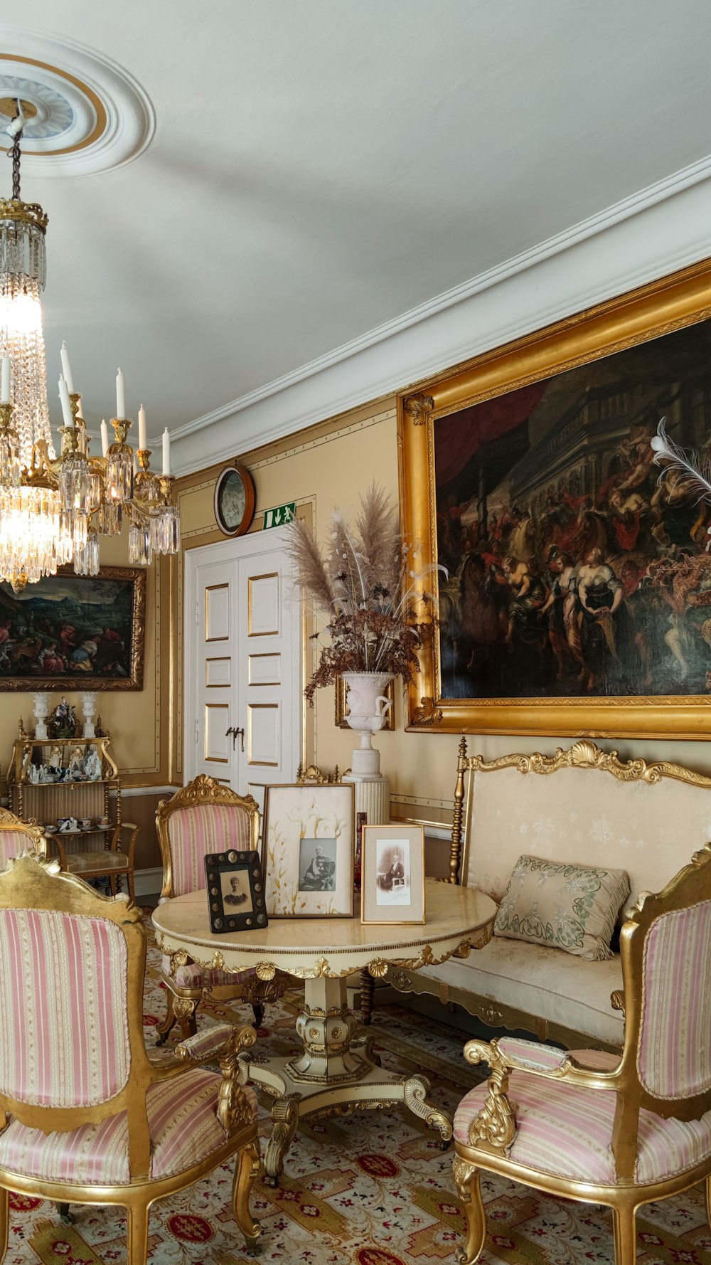 a living room with a chandelier and a painting on the wall