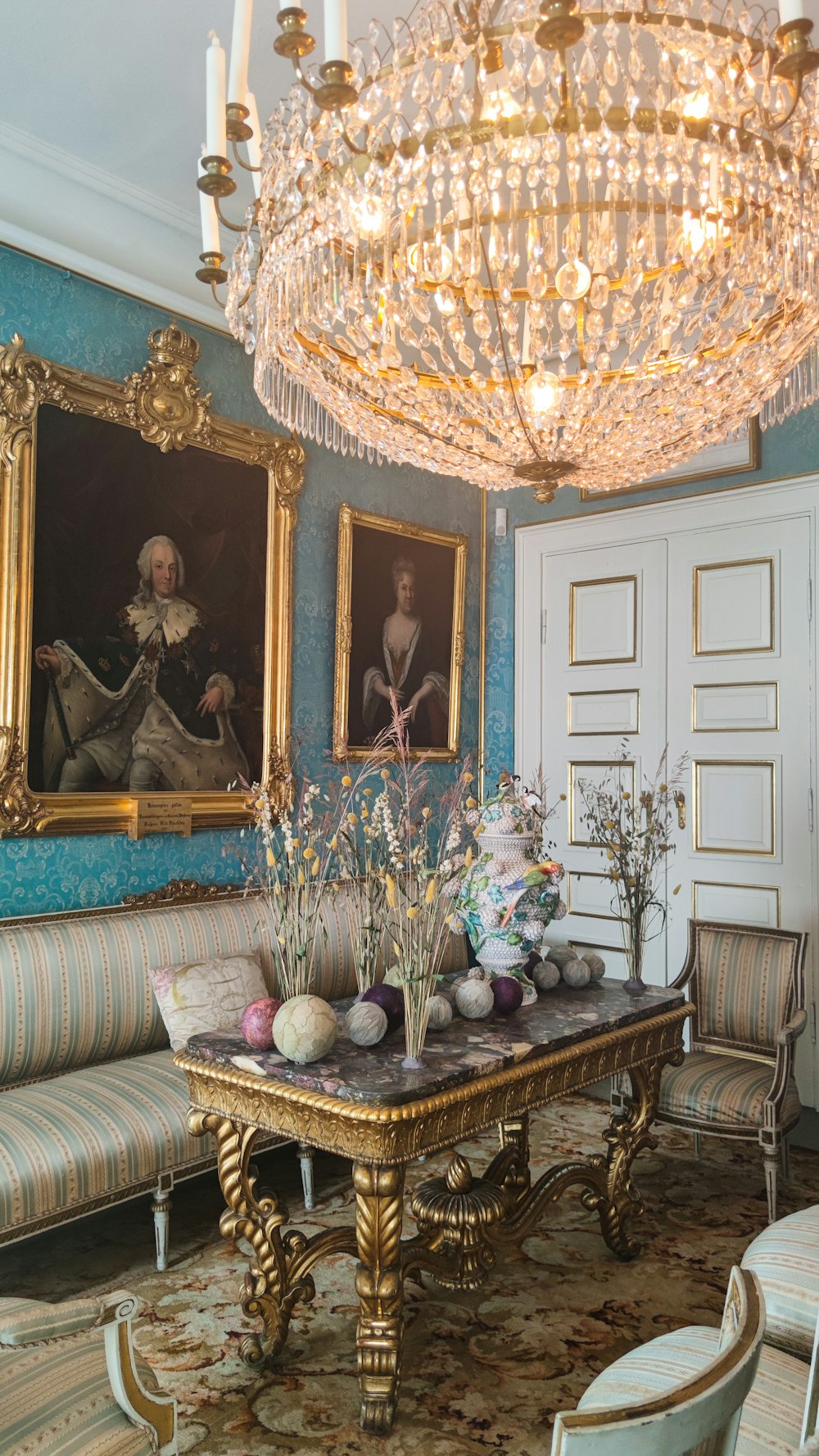 a living room with a chandelier and paintings on the wall