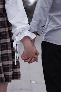a close up of two people holding hands