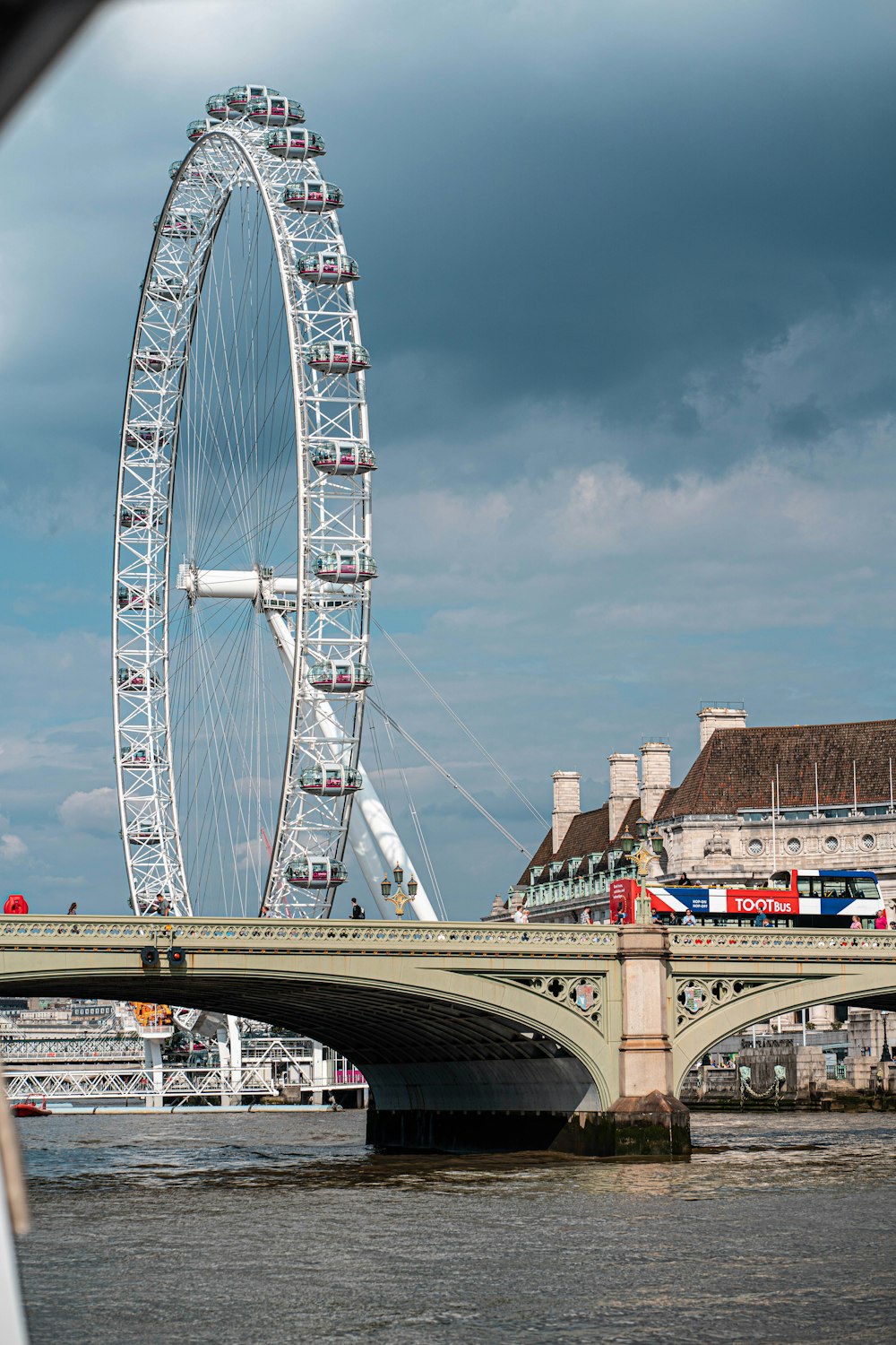 a large ferris wheel on a bridge over a body of water