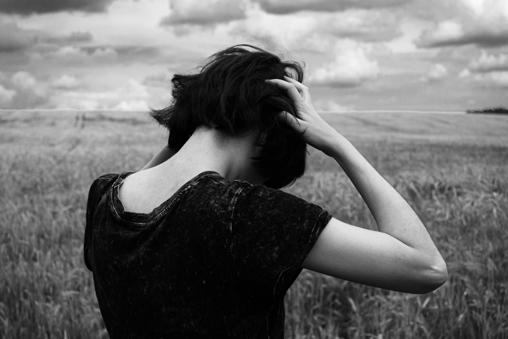 a woman standing in a field of tall grass