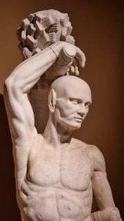 a statue of a man holding a flower in his hair