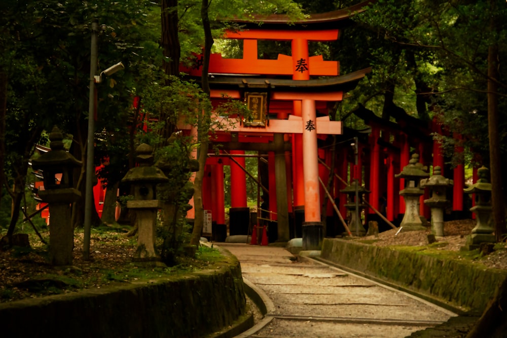 a path leading to a red building in a forest