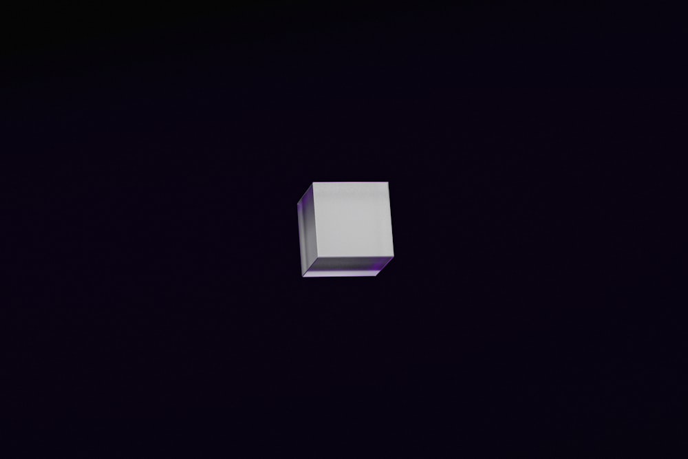 a white box sitting in the middle of a dark room