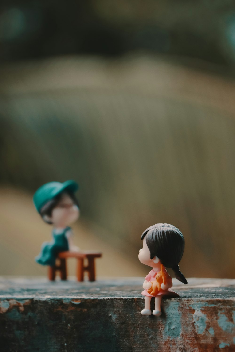 A couple of small figurines sitting on top of a wooden table photo ...