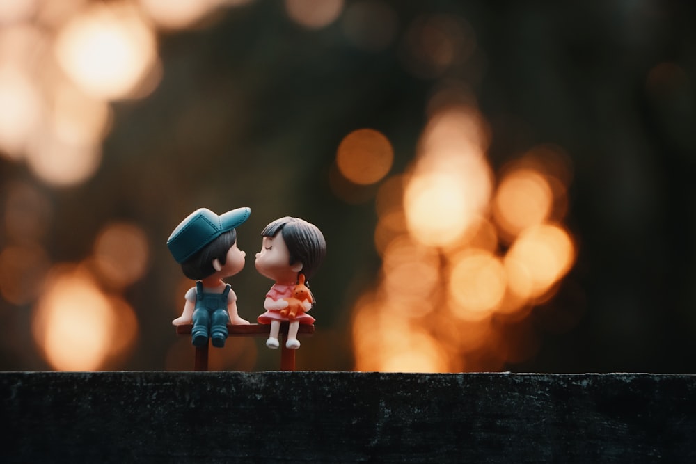 a couple of small figurines sitting on top of a wooden table