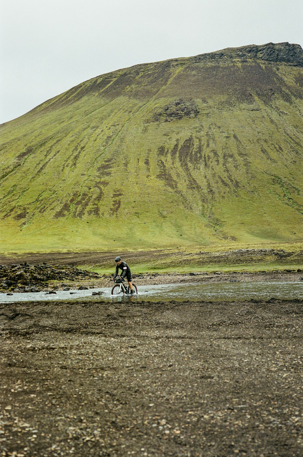 Un hombre montando en bicicleta por un camino fangoso