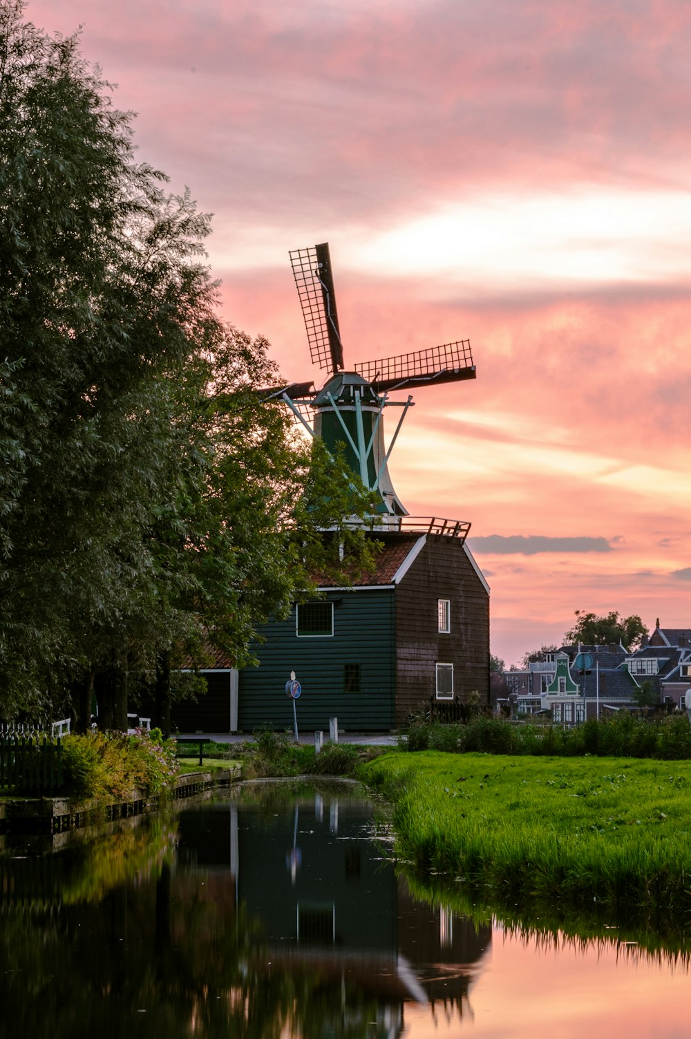 a windmill sitting next to a body of water