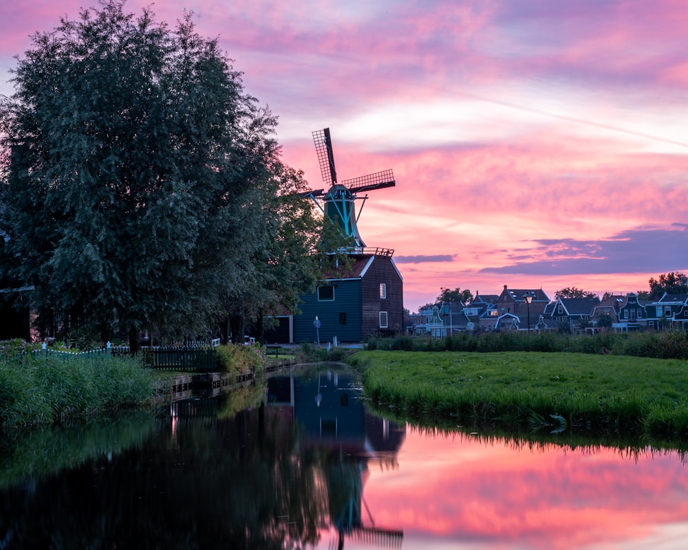 a windmill sitting next to a body of water