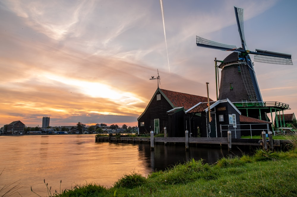 a windmill sitting next to a body of water