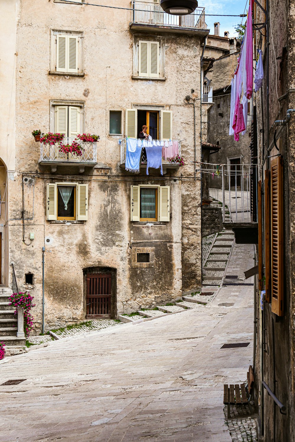 an old building with a balcony and a balcony with flowers on it