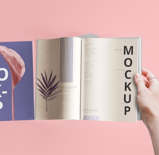 a hand holding a book open to a mockup