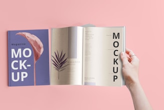 a hand holding a book open to a mockup
