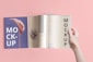a hand holding a book open to a mockup