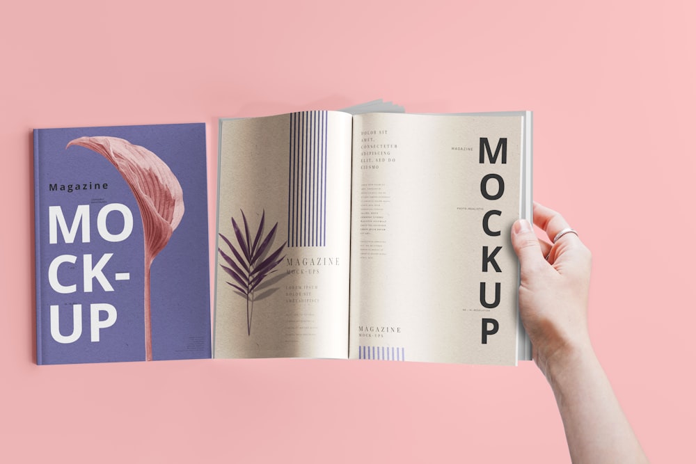 a hand holding a book open to a mockup