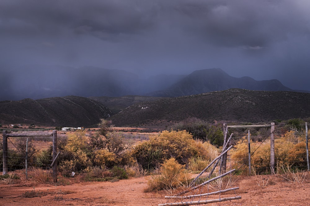 a wooden gate sitting in the middle of a dirt field