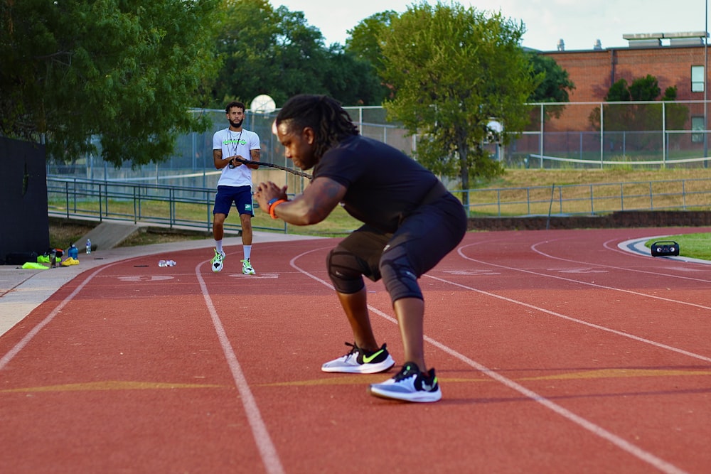 two people on a track with a tennis racket