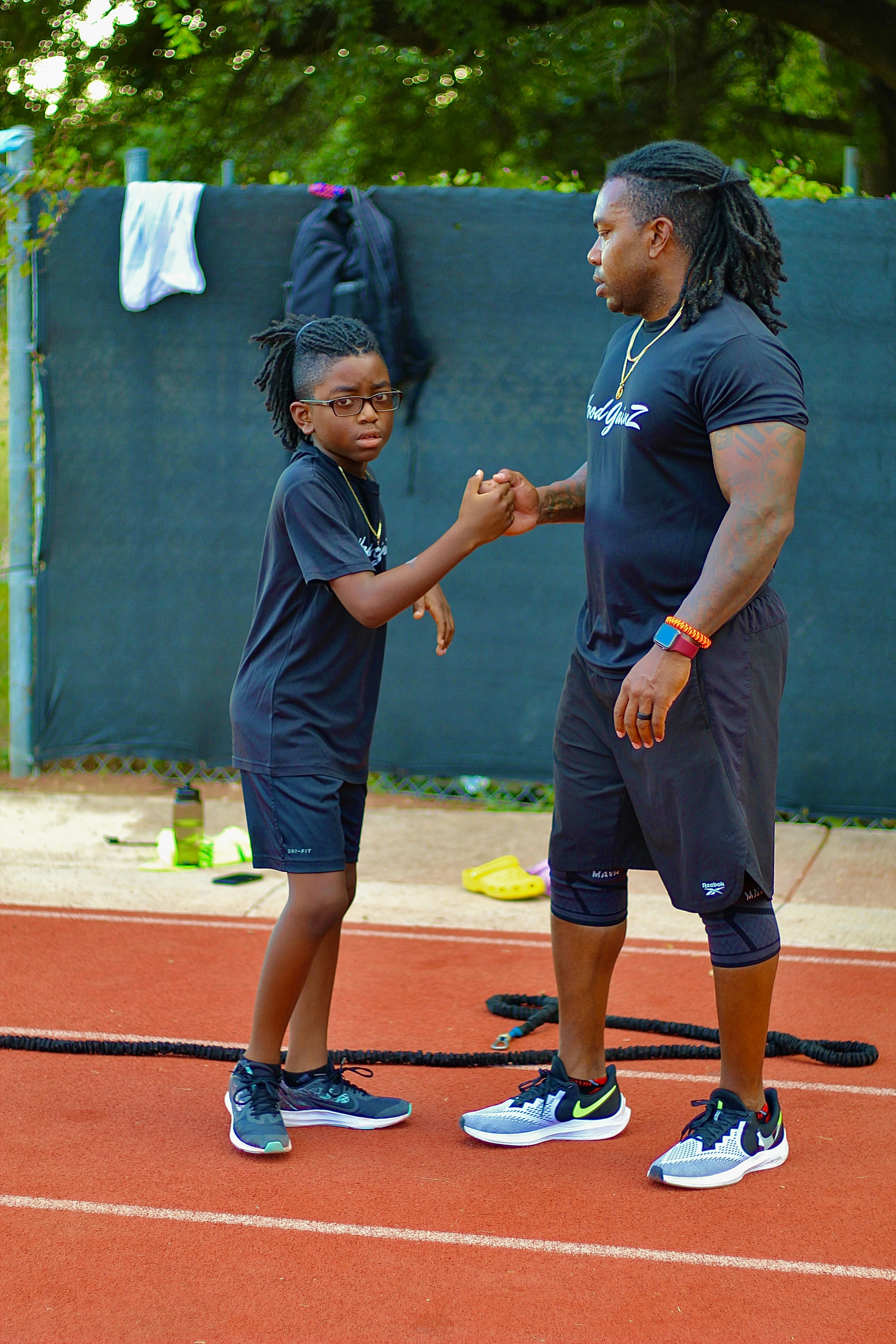 a man and a little girl shaking hands on a tennis court