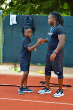 a man and a little girl shaking hands on a tennis court