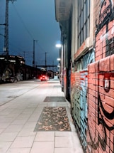 A lively street scene in Bogotá at dusk with colorful graffiti walls and bustling nightlife.