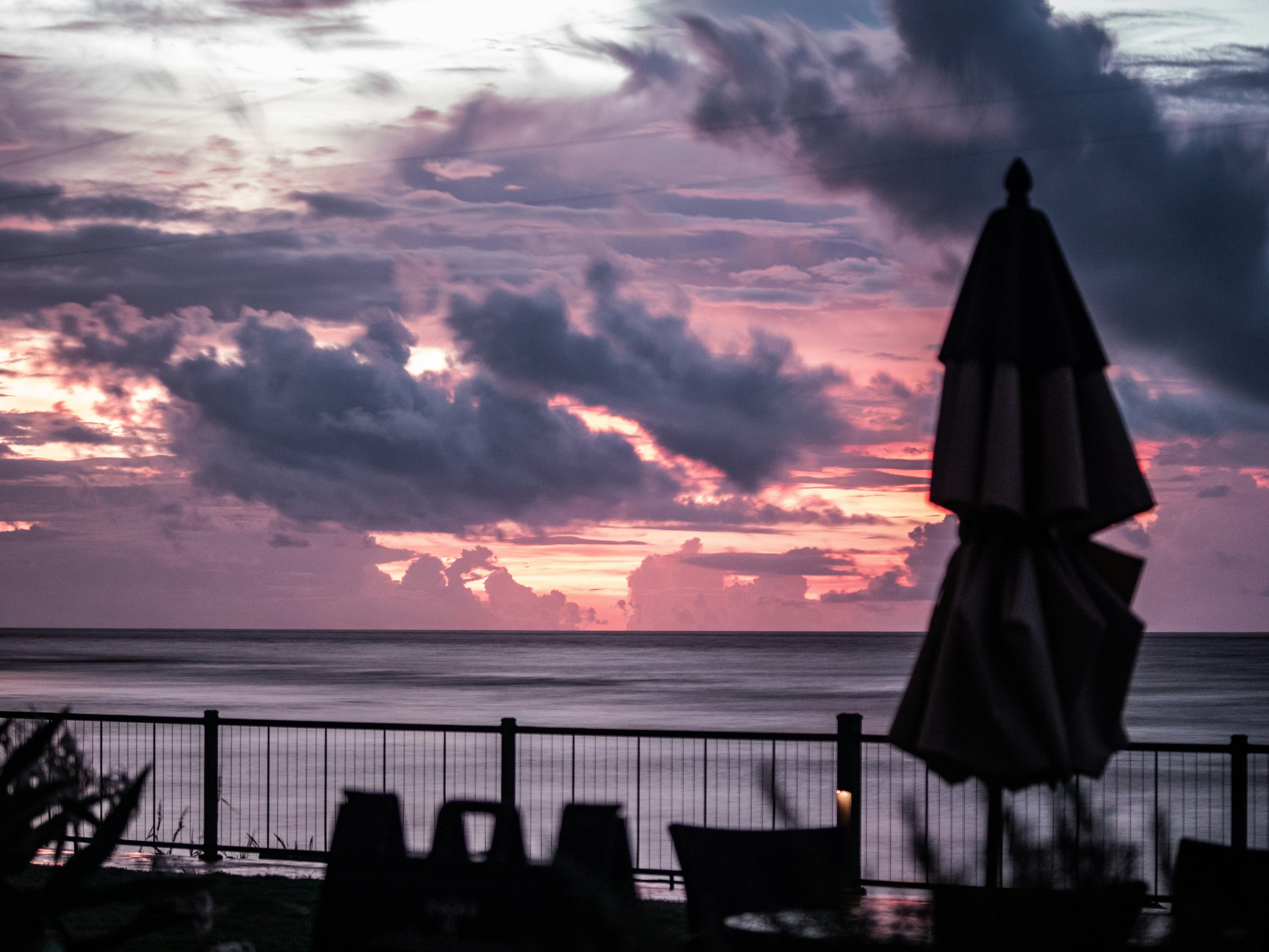 a view of a sunset over the ocean from a restaurant, 