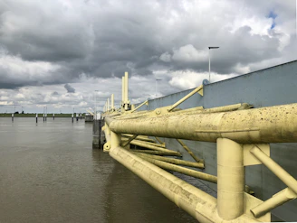 Engineer assessing a site beside a waterway with flood barriers in place.